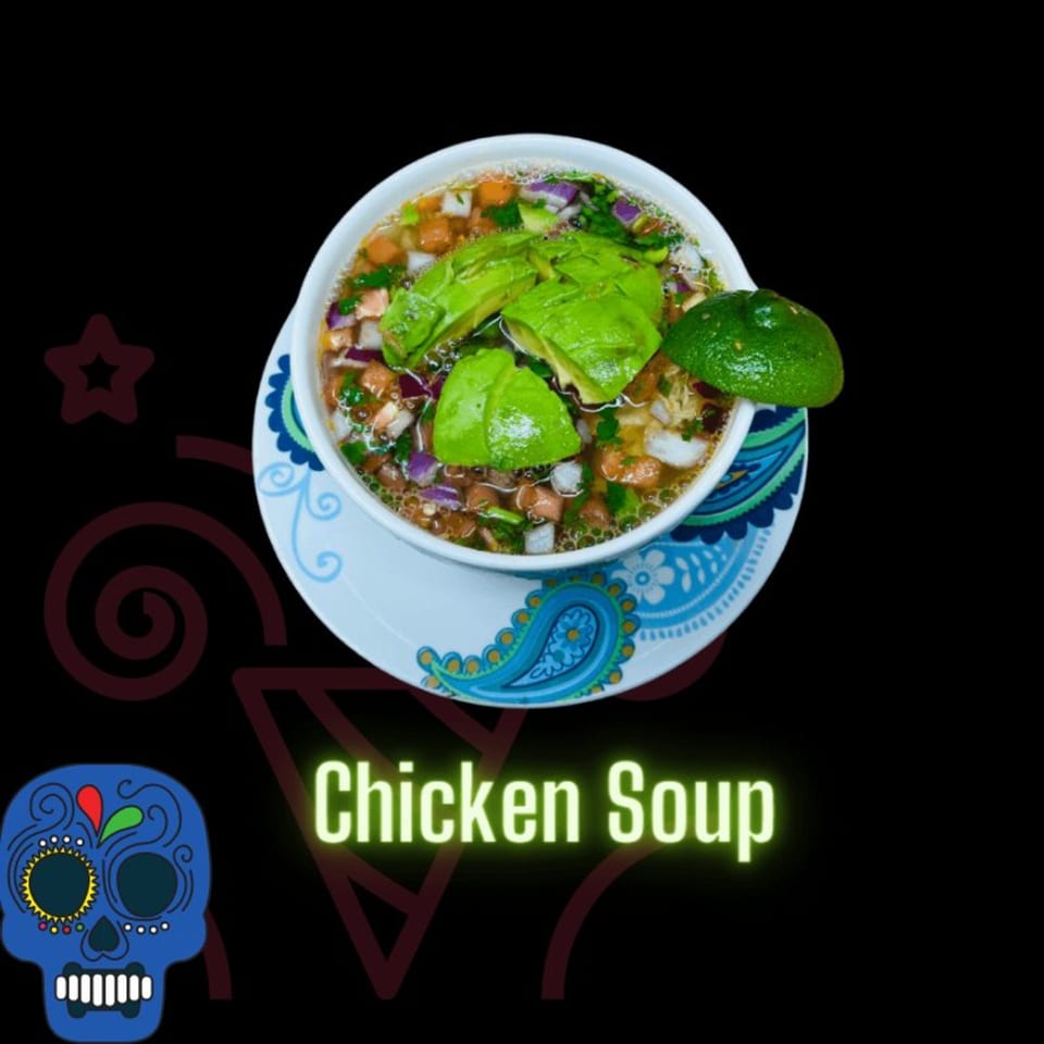 Don Tequila Amherst's chicken soup with avocado, red onion, and lime on a decorative plate.